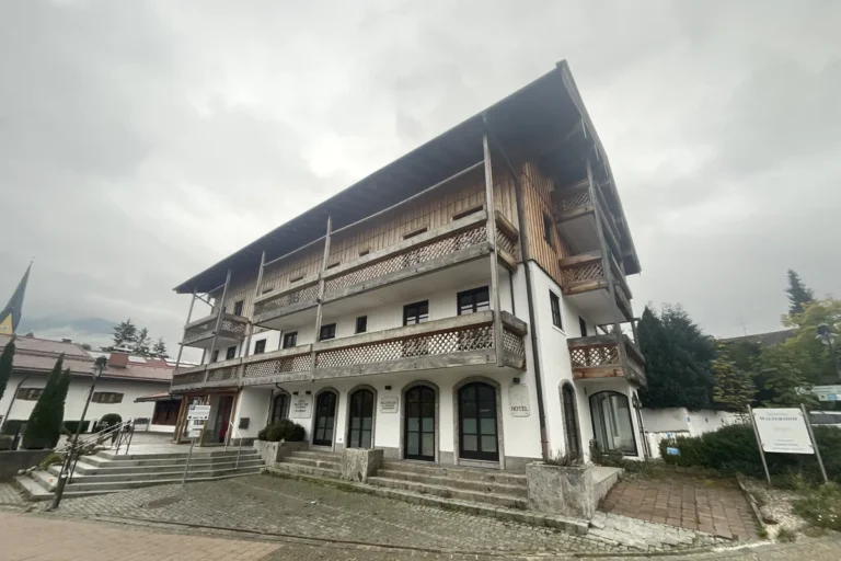Hotelgebäude mit Holzbalkonen und weit auskragendem Dach in Oberbayern
