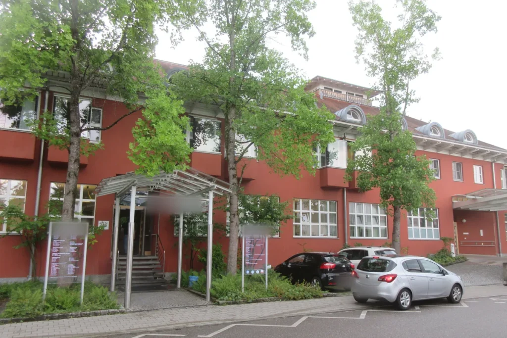 Klinikgebäude mit roter Fassade und überdachtem Eingangsbereich