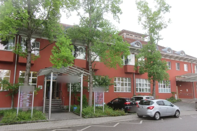 Klinikgebäude mit roter Fassade und überdachtem Eingangsbereich