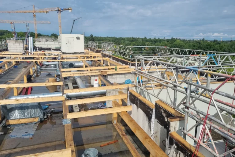 Dachbaustelle mit Lüftungsleitungen und Gerüst an einem Mehrfamilienhaus in der Murnauer Straße in München